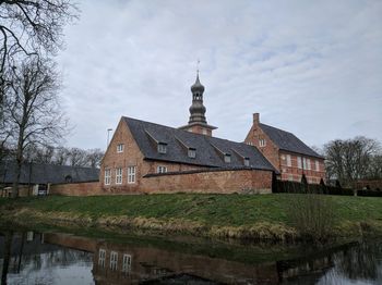 Building by canal against sky