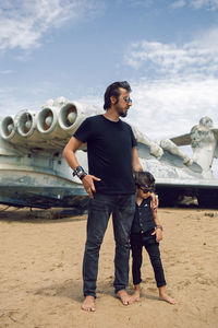 Family a boy and his father in rocker clothes stand  ekranoplan plane by the sea in dagestan
