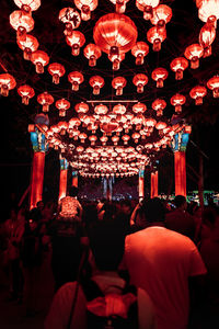 Group of people in illuminated lanterns at night