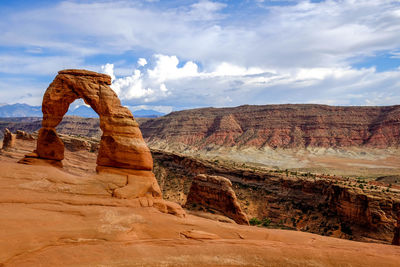 Rock formations in desert against cloudy sky