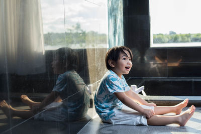 Side view of woman looking through window
