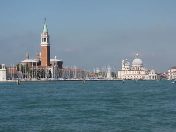 View of buildings by sea against sky