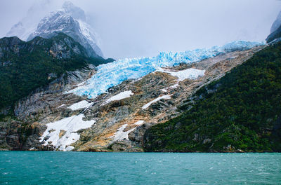 Melting glacier against foggy mountain 