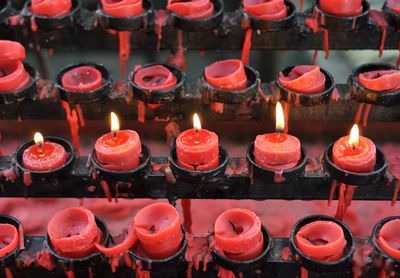 High angle view of illuminated red candles at church