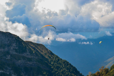 Low angle view of person paragliding against sky