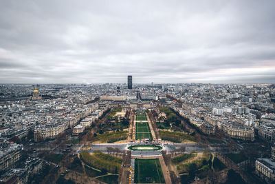 Aerial view of cityscape against cloudy sky