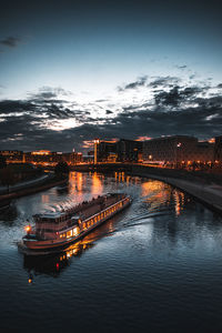 Ship sailing on river against sky at dusk