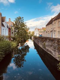 Canal amidst buildings against sky