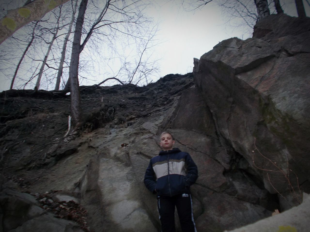 lifestyles, rock - object, leisure activity, standing, low angle view, rock formation, men, sky, mountain, tree, rear view, built structure, sunlight, nature, full length, day, casual clothing, rock