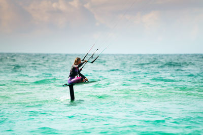 Man swimming in sea against sky