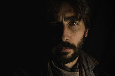 Young man's face standing out from a dark background