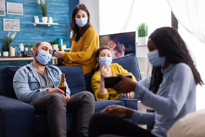 Cheerful people wearing mask looking at mobile phone