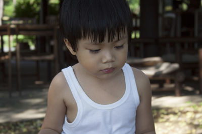 Close-up of boy looking down outdoors