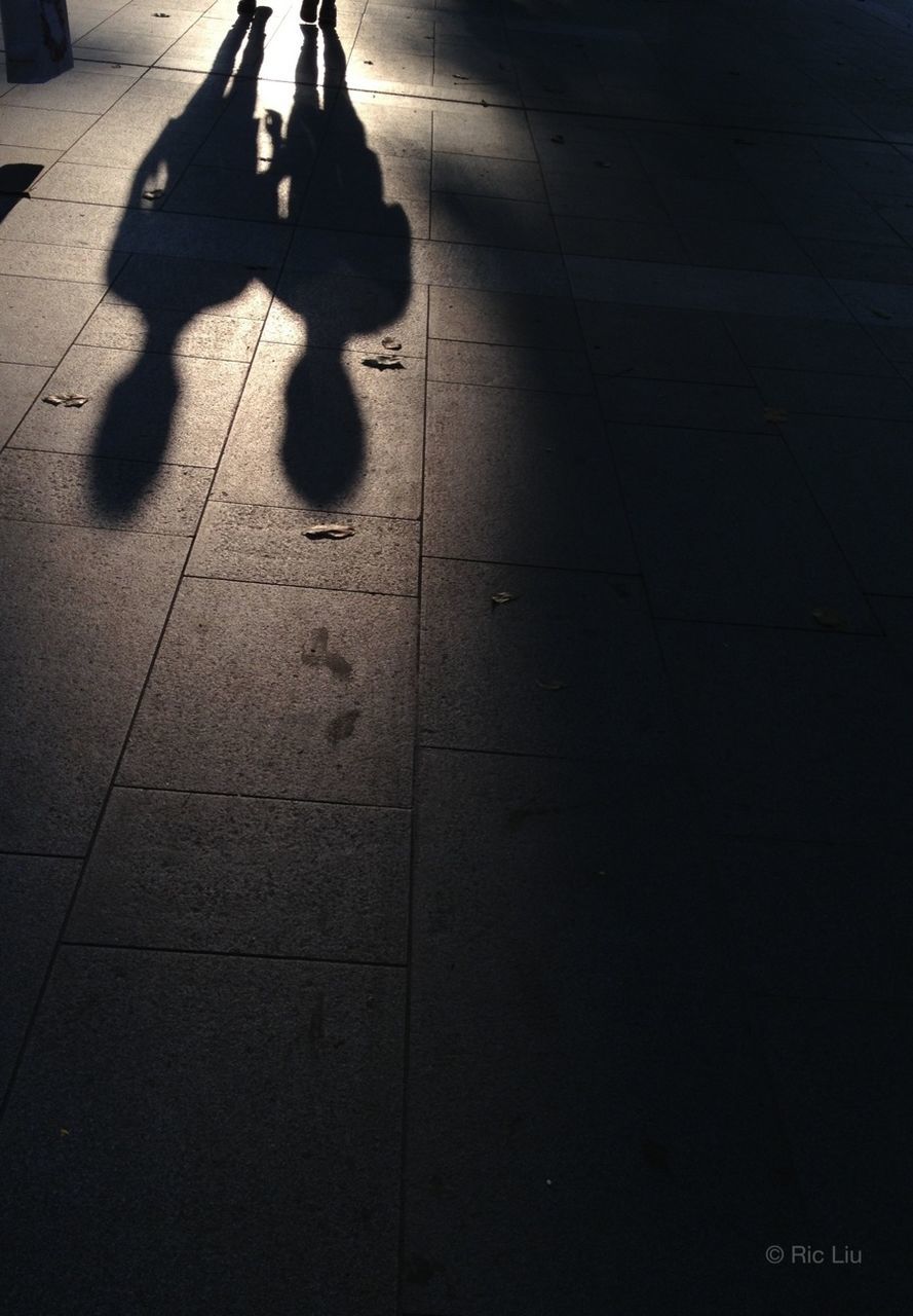 shadow, men, lifestyles, walking, silhouette, leisure activity, low section, street, person, sunlight, unrecognizable person, focus on shadow, high angle view, medium group of people, togetherness, standing, city life