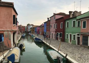 Canal amidst houses against sky in city