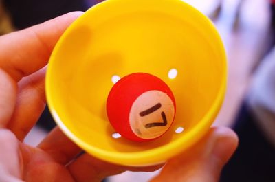 Close-up of person holding number 17 ball in container