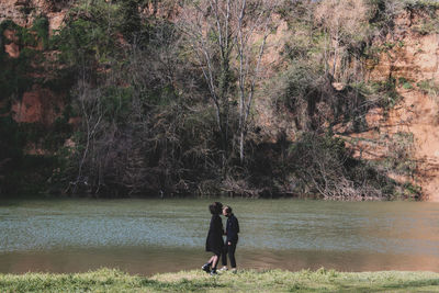 Full length of woman standing by lake