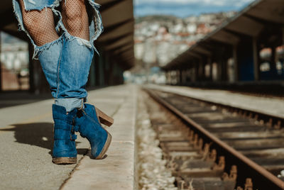 Low section of man standing on railroad track