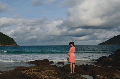 Rear view of man looking at sea against sky