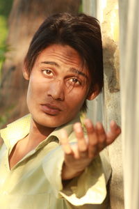 Close-up portrait of man leaning on wall