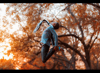 Full length of man in autumn tree