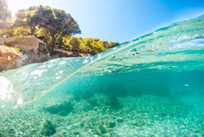 Swimming pool by sea against blue sky