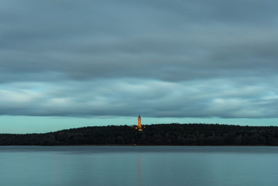 Lighthouse by lake against sky