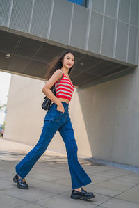 Full length of young woman standing in city