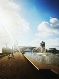 Fountain by river against sky in city