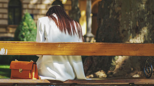 Rear view of woman sitting on bench