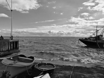 Boats moored on sea against sky