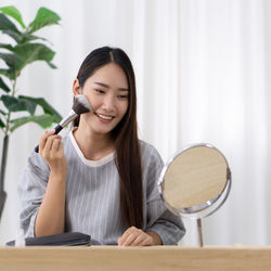 Portrait of a smiling young woman sitting on table