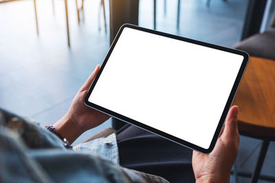 Mockup image of a woman holding digital tablet with blank white desktop screen