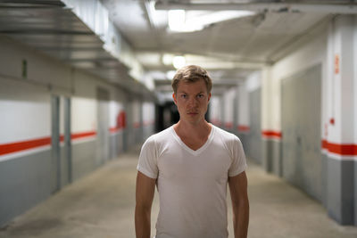 Portrait of young man standing at railroad station