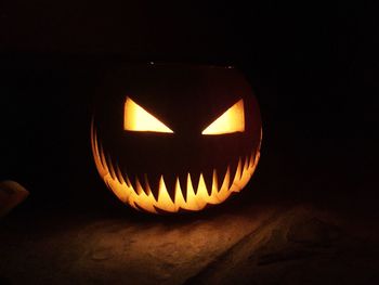 Close-up of illuminated pumpkin against black background
