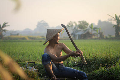Full length of man sitting in field