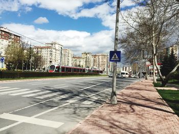 View of city street against cloudy sky