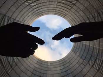 Silhouette of two men against cloudy sky