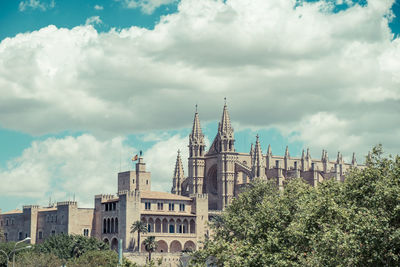 Low angle view of cathedral against cloudy sky during sunny day