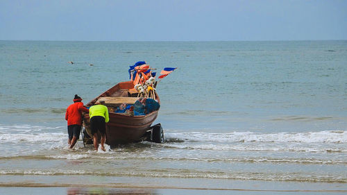 People at beach against sky