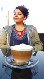 Young woman with coffee cup on table