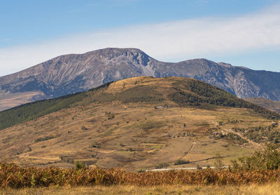 Scenic view of field and mountains against sky