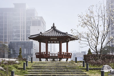 Gazebo in park against buildings in city