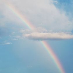 Low angle view of rainbow in cloudy sky