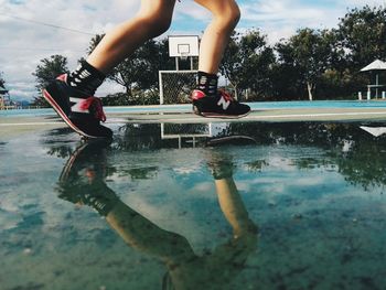 Low section of person with reflection in puddle