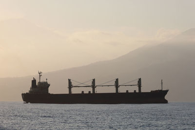 Silhouette ship on sea against sky during sunset