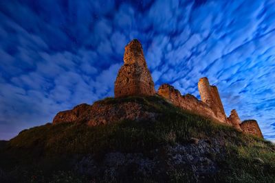 Low angle view of rock formation against sky