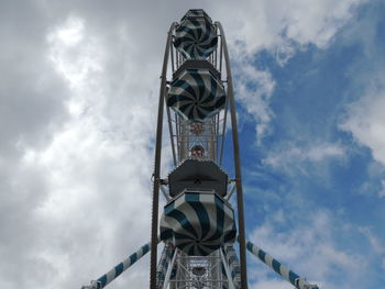 Low angle view of ferris wheel against cloudy sky