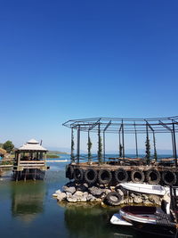 Ship moored in lake against clear blue sky