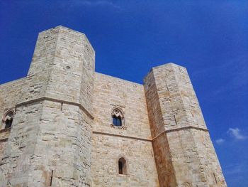 Low angle view of old building against blue sky